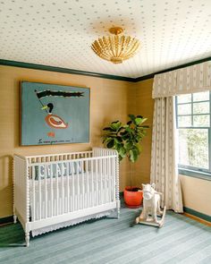 a baby's room with a crib, rocking horse and potted plant