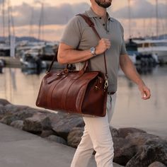 We designed the leather Weekender bag to be practical, spacious, and timelessly elegant—a men's holdall that fits everything you need. Handcrafted in Northern Italy by experienced craftsmen in family-owned studios, the Weekender is made from full-grain vegetable-tanned cow leather of exquisite quality. Smooth yet robust top leather handles make it easy to carry and there's an adjustable leather shoulder strap too which you can easily remove when necessary. The spacious main compartment of this o Timeless Leather Duffle Bag For Everyday Use, Luxury Everyday Bags In Bridle Leather, Leather-lined Weekender Bag For Everyday Use, Modern Briefcase, Leather Garment Bag, Mens Weekend Bag, Leather Briefcase Men, Leather Weekender Bag, Leather Weekender