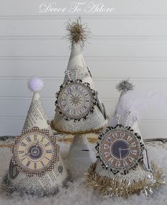 three small white christmas trees with clocks on them