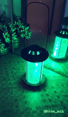 two green lanterns sitting on top of a tiled floor