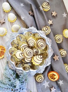 a bowl filled with oranges and white chocolate candies on top of a table