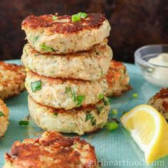 crab cakes stacked on top of each other with lemon wedges