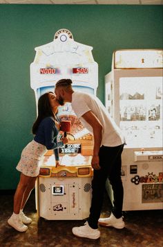 a man and woman kissing in front of a machine