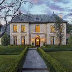 a large house with lots of plants in front of it