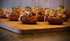 baked potatoes with meat and vegetables on a cutting board