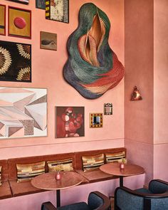 a restaurant with pink walls and artwork on the wall