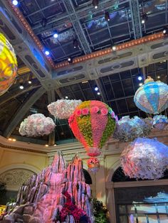 many colorful lights hanging from the ceiling in a building