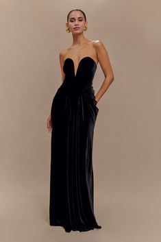 A velvet dream. The PAIGE Strapless Velvet Maxi Dress combines elegance with sultry sophistication. Featuring a strapless design and a deep plunge neckline, it beautifully accentuates the décolletage. The corset waist shapes and defines your figure, while gathering at the hips adds movement and volume, creating a flattering silhouette. Crafted from rich velvet, the dress has a luxurious finish that catches the light with every step. With a centre-back zip for a secure fit, the maxi length offers Corset Waist, Velvet Maxi Dress, Velvet Maxi, Deep Plunge, Plunge Neckline, Plunging Neckline, Black Maxi Dress, Latest Fashion Trends, Latest Fashion