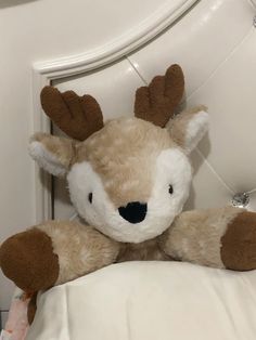 a stuffed animal with antlers sitting on top of a bed