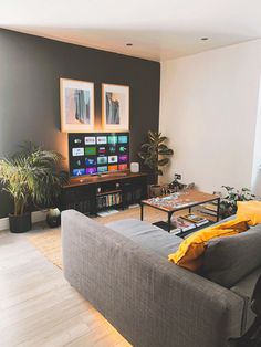 a living room filled with furniture and a flat screen tv sitting on top of a wooden table