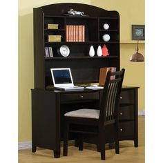 a desk with a laptop on top of it in front of a bookcase and chair