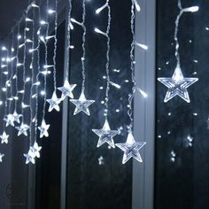 some white stars hanging from the side of a window