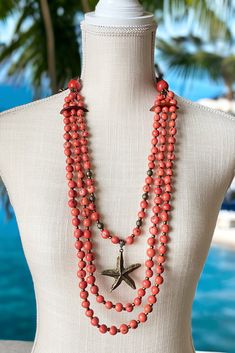 A striking necklace in coral perfect for your summer getaway! I made this beachy, resort wear necklace with a stunning color scheme of coral and antique brass. I used acai seeds in coral, tagua nut beads and bombona seeds, and an antique brass starfish pendant. Pair it with our Noemi hoops in coral to complete your look! Bohemian Orange Necklace For Vacation, Bohemian Starfish Necklace For Vacation, Coral Beaded Necklaces With Round Beads For Beach, Coral Beaded Necklace With Round Beads For Beach, Bohemian Coral Jewelry For The Beach, Bohemian Coral Jewelry For Beach, Coral Bohemian Beach Jewelry, Orange Multi-strand Jewelry For Beach, Orange Multi-strand Jewelry For The Beach