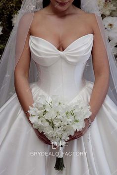 a woman in a wedding dress holding a bouquet