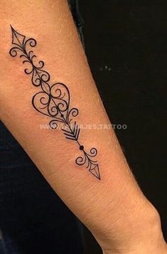 a woman's arm with an arrow tattoo on it