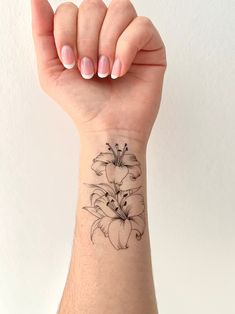 a woman's wrist tattoo with flowers on it