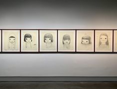 five drawings are hanging on the wall next to each other in front of a woman's head