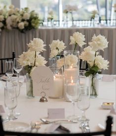 the table is set with candles, flowers and place cards for guests to sit at