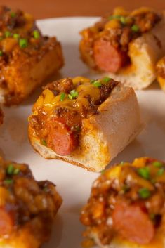 small appetizers with meat and cheese on them are arranged on a white plate