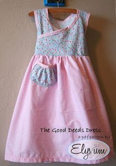 a pink and white dress hanging on a wall next to a blue sign that says the good seeds dress