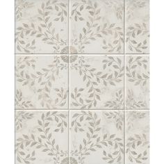 a white tile wall with grey leaves on the top and bottom panel, in an ornate pattern