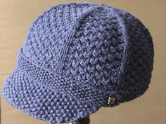 a crocheted blue hat sitting on top of a mannequin's head