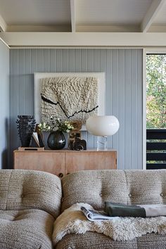 a living room filled with furniture and a painting on the wall above it's headboard