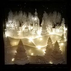 a lighted window with trees and buildings in the background