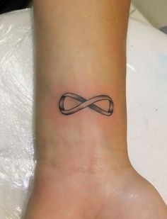 a wrist tattoo with an infinite symbol on it