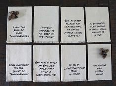 four pieces of cloth with words written on them sitting on top of a wooden table