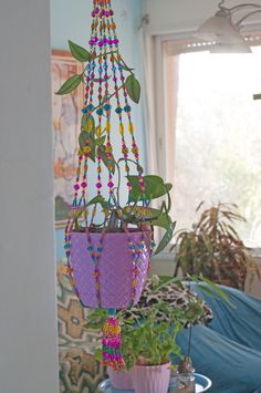 a hanging planter filled with beads and plants