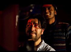 two men standing next to each other with their faces painted red and black in the dark