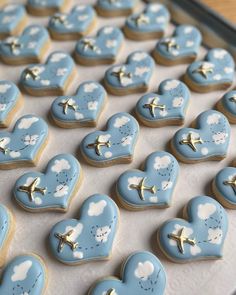 heart shaped cookies with airplanes and clouds in the shape of hearts on a baking sheet