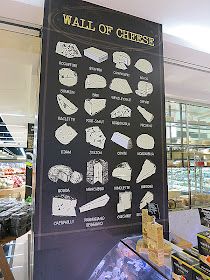 a sign showing the wall of cheese in a store