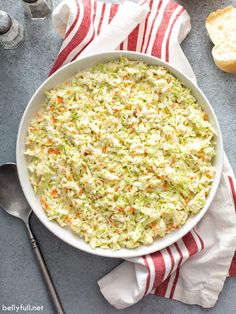 a white bowl filled with coleslaw and carrots on top of a table