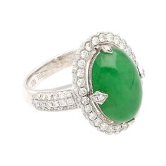 This is part of Chairish’s Fine Jewelry assortment.  Introducing a captivating 18K White Gold Ring, weighing 7.04 grams and adorned with a prong setting for timeless elegance. At the heart of this ring is a vibrant 7.29 carat cabochon-cut "A" grade Jadeite Jade, showcasing a rich green hue. Accentuating the Jade are 126 round-cut Diamonds, totaling 1.19 carats, delicately arranged to enhance the ring's overall brilliance.  Fixed with an intricate milgrain finish around the gemstones.   Item Deta Classic Jade Rings For Formal Occasions, Elegant White Gold Jade Rings, Luxury Jade Ring For Formal Occasions, Elegant Jade Ring For Anniversary, Luxury Jade Rings, Elegant Formal Jade Rings, Elegant Green Diamond Ring With Polished Finish, Fine Jewelry Jade Ring For Formal Occasions, Formal Jade Rings Fine Jewelry