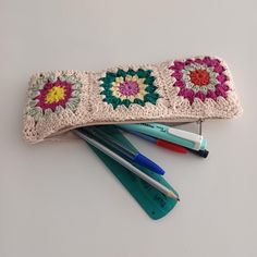 three crocheted pencils and markers are laying next to each other