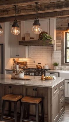 a kitchen with two stools in front of the island and three lights above it