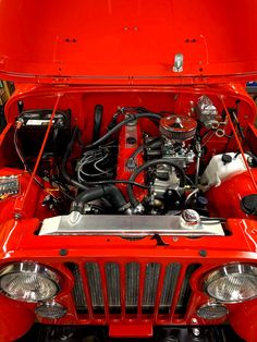 the engine compartment of an old red jeep