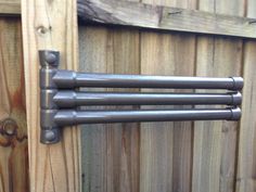 an image of a metal towel rack on the side of a wooden fence with wood slats in the background