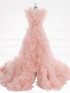 a pink dress hanging on a mannequin in front of a white wall and door