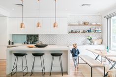 a woman standing in front of a kitchen island