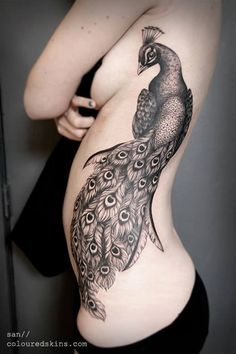 a woman with a peacock tattoo on her stomach