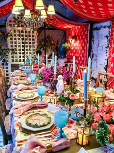 a long table with place settings and flowers on it