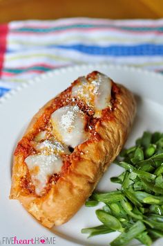 a piece of pizza on a plate with green beans