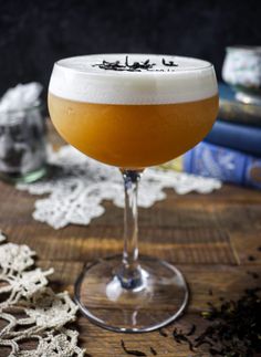 a close up of a drink in a glass on a table with lace doily