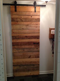 a door made out of wooden planks in a room with a phone on the wall