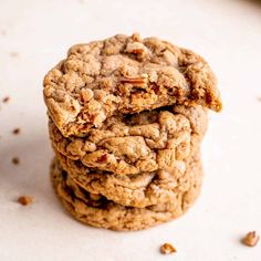 three cookies stacked on top of each other with pecans scattered around them and one cookie in the middle