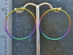 "These niobium 1 1/8\" (29 mm) Hoop Earrings are hand-forged. They are made by winding 1/2 hard 18 gauge (1.024 mm) round niobium wire on a mandrel. They are then given the catch loop, filed and polished. I then anodize them. This style of hoop is often referred to as a \"sleeper\" hoop because they are small and will lay somewhat flatter against the head than a post earring will. Please allow for some handmade variation. These are light and comfortable to wear. I sell them by the pair. Please s Hypoallergenic Rainbow Hoop Earrings As Gift, Small Multicolor Hypoallergenic Hoop Earrings, Rainbow Hoop Earrings With Ear Wire, Small Rainbow Hoop Earrings For Pierced Ears, Adjustable Rainbow Hoop Earrings With Ear Wire, Rainbow Hypoallergenic Hoop Earrings, Hypoallergenic Rainbow Hoop Earrings, Neon Hoop Earrings, Gold-tone Hypoallergenic Hoop Earrings