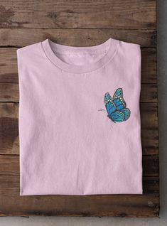 Butterfly embroidered t-shirt is a beautiful gift for a special one in your life! Embroidered on 100% Cotton, Comfort Colors Brand T-shirts. This design is simple and minimalistic, perfect for every outfit! Retail fit Unisex sizing Cover stitched collar and sleeves Shoulder-to-shoulder taping Side seams Tear away label Pink Crew Neck T-shirt With Embroidered Graphics, Pink Cotton T-shirt With Embroidered Graphics, Pink T-shirt With Embroidered Graphics And Relaxed Fit, Pink Short Sleeve T-shirt With Embroidered Graphics, Pink T-shirt With Embroidered Graphics In Relaxed Fit, Pink Relaxed Fit T-shirt With Embroidered Graphics, Pink Short Sleeve T-shirt With Custom Embroidery, Spring Pink T-shirt With Custom Embroidery, Spring Crew Neck T-shirt With Butterfly Embroidery